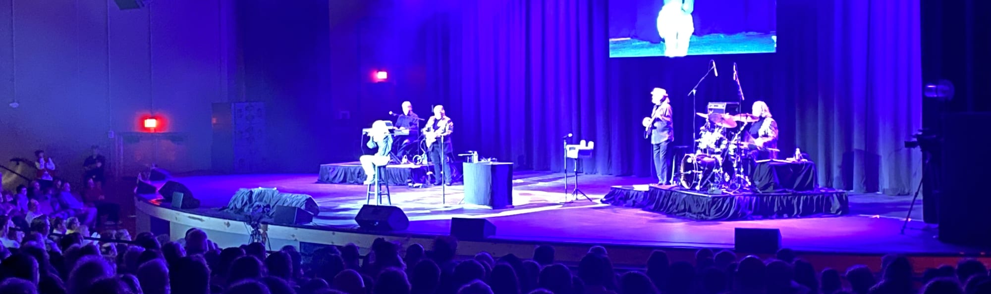 signer on stage in chair washed out by the lights Huntsville